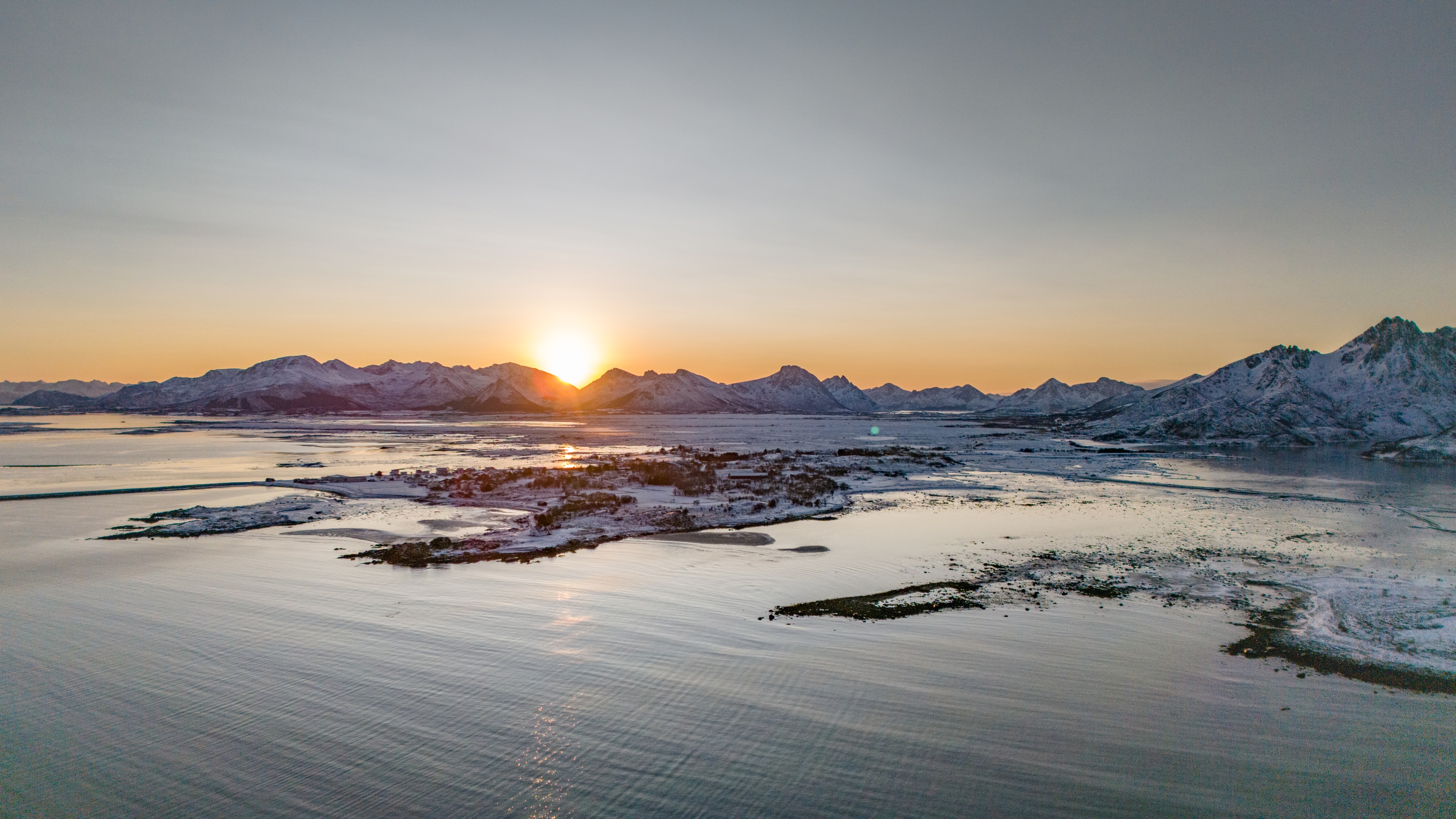 Soleil bas au-dessus des montagnes et des îles enneigées d’Øksnes
